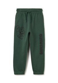 Grüne Sweatpants aus Baumwollmischung, mit einem Mario-Graphic auf der linken Seite und dem Text "SUPER MARIO" auf der rechten. Elastischer Bund.