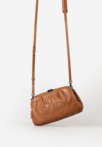 Bruine leren crossbodytas met een geplooide ontwerp, voorzien van een bovenklep, een verstelbare schouderband en zwarte hardwareaccenten.