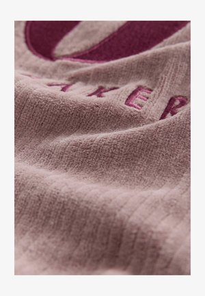 Struktūruota šviesiai rožinė medžiaga su vagotu raštu, turinti tamsiai rožinius siuvinėtus raides ir lygų paviršių.