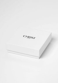 Weißer Karton mit glatter Textur, auf dem Deckel befindet sich ein schwarzes Logo mit der Aufschrift "CHRIST" und dem Text "seit 1863".