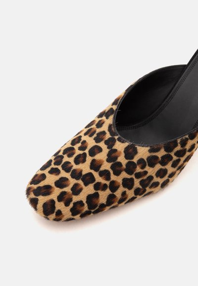 Gros plan d'une chaussure à imprimé léopard avec un bout carré arrondi et une doublure intérieure noire sur fond blanc.