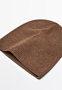 Bruine gebreide beanie met een geribbelde rand, gekenmerkt door een zachte textuur en een eenvoudig, naadloos ontwerp. Geschikt voor warmte in koudere weersomstandigheden.