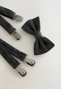 Mustad traksid tekstuurse paisley mustriga ja hõbedaste metallkinnitusdetailidega, millele on lisatud sobiv lipsu vibu. Mõlemad on valmistatud kangast.