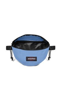 Světle modrá ledvinka Eastpak s černým nastavitelným popruhem, otevřený zip ukazuje černou vnitřní podšívku.