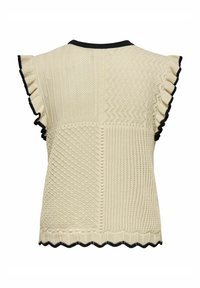 Top en tricot de couleur crème, avec des motifs texturés, des manches volantées, une bordure noire au col et à l'ourlet, et un bord inférieur en forme de vagues.