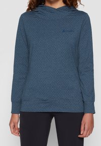 Sudadera con capucha en azul oscuro con un patrón texturizado y manchas claras. Presenta un bolsillo frontal y puños de canalé.
