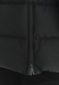 Czarna pikowana kurtka z centralnym zamkiem błyskawicznym, wykonana z miękkiego, gładkiego materiału z minimalnym zdobieniem.