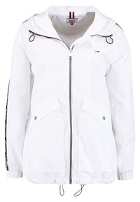 Biała, lekka kurtka z kapturem, zamek błyskawiczny z przodu, dwie boczne kieszenie, ściągacz w dolnej części, czarne detale akcentujące oraz logo Tommy Hilfiger.