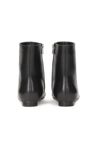 Botas de tobillo de cuero negro con un diseño elegante, que cuentan con cremalleras en la parte trasera y una punta redonda, textura suave y tacones bajos y planos.