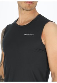Zwarte mouwloze sportshirt met een ronde halslijn en het "SWEDEMOUNT" logo in het wit. Heeft een gladde, gestructureerde stof.