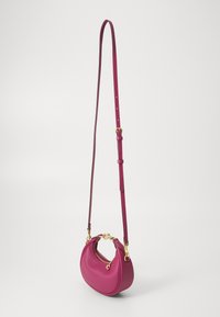 Fuchsiová kožená crossbody taška s oblým tvarem, zlatými kovovými detaily a zipem. Obsahuje nastavitelný popruh.