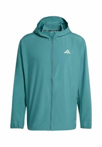 Chaqueta ligera color verde azulado con cremallera y capucha, fabricada con tejido suave. Presenta un logo blanco en el lado izquierdo del pecho y puños elásticos.