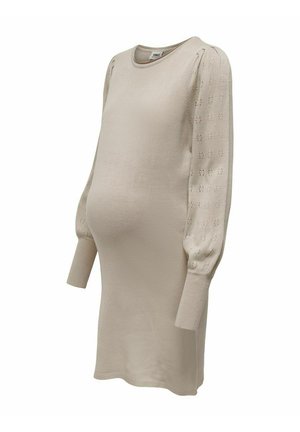Ljusbeige stickad gravidklänning med långa ärmar, med texturerade puffärmar och ribbade muddar, designad för komfort och stil.