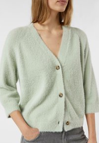 Minzgrüner Cardigan aus weichem Stoff, mit V-Ausschnitt, dreiviertellangen Ärmeln und drei runden Knöpfen vorne.