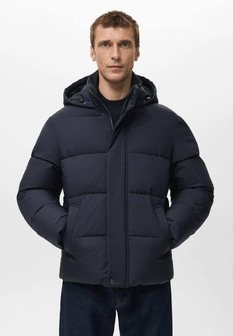 Granatowa puchowa kurtka z kapturem, z kwadratowymi pikowanymi sekcjami, dwiema przednimi kieszeniami i zamkiem błyskawicznym. Wykonana z wodoodpornego materiału.