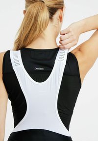 Czarny top sportowy z białymi siateczkowymi ramiączkami i teksturowanym materiałem. Charakteryzuje się designem typu racerback, podkreślającym oddychalność i komfort.