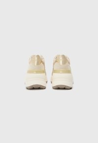 Beige sneakers med en jevn metallisk gullhelsdel og strukturert semsket overdel. Kraftig gummisåle med mønster.