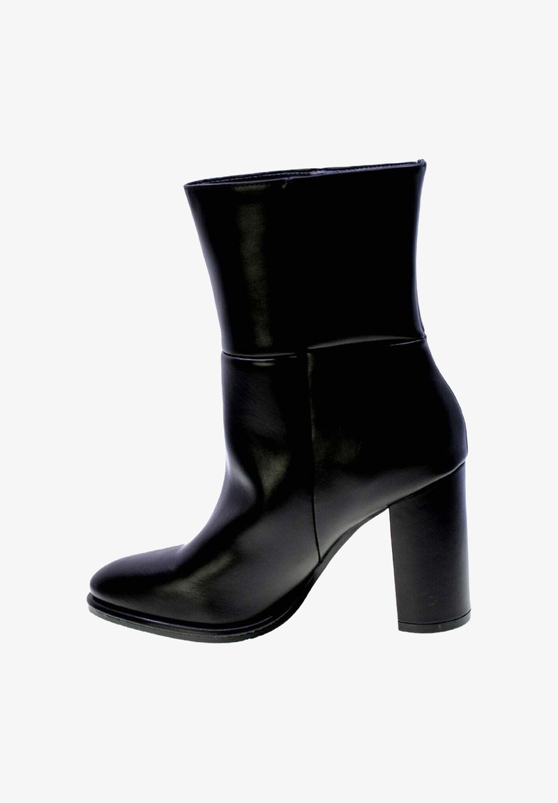 Botte de cheville en cuir noir au design épuré, avec un bout pointu et un talon épais. Texture lisse avec un minimum de détails et une silhouette structurée.