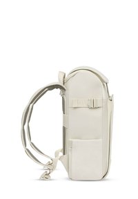 Beiger Rucksack mit abgerundetem Oberteil, gepolsterten Trägern, Seitentasche, verstärktem Boden und glatter Oberfläche; verfügt über einen verstellbaren Schnallenverschluss auf der Vorderseite.