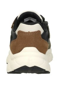 Zwarte sneaker met een suède bruine accent bij de hak, een getextureerde witte tussenzool en een groenachtige zijplaat. De achterkant toont het stiksels detail.