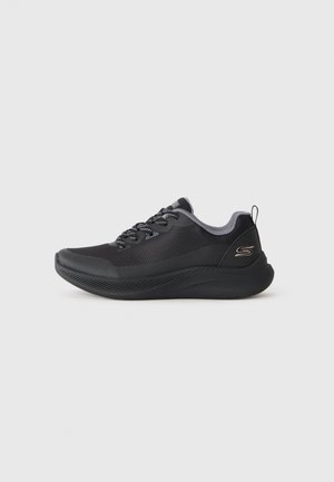 Czarny lekki sportowy sneaker z siateczkową cholewką, wyściełaną podeszwą, wzorzystymi sznurówkami i zawieszką na pięcie na jednolitym tle.