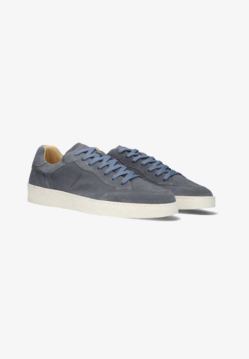 Zwei graue Wildledersneaker mit hellblauen Schnürsenkeln, einer strukturierten weißen Gummisohle und einem minimalistischen Design; das Innere verfügt über eine glatte Fütterung.