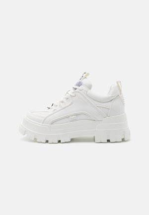 Hvid chunky platform-sneaker med tekstureret sål, mesh- og læderpaneler, snørelukning foran og mærkede trækstropper på tunge og hæl.