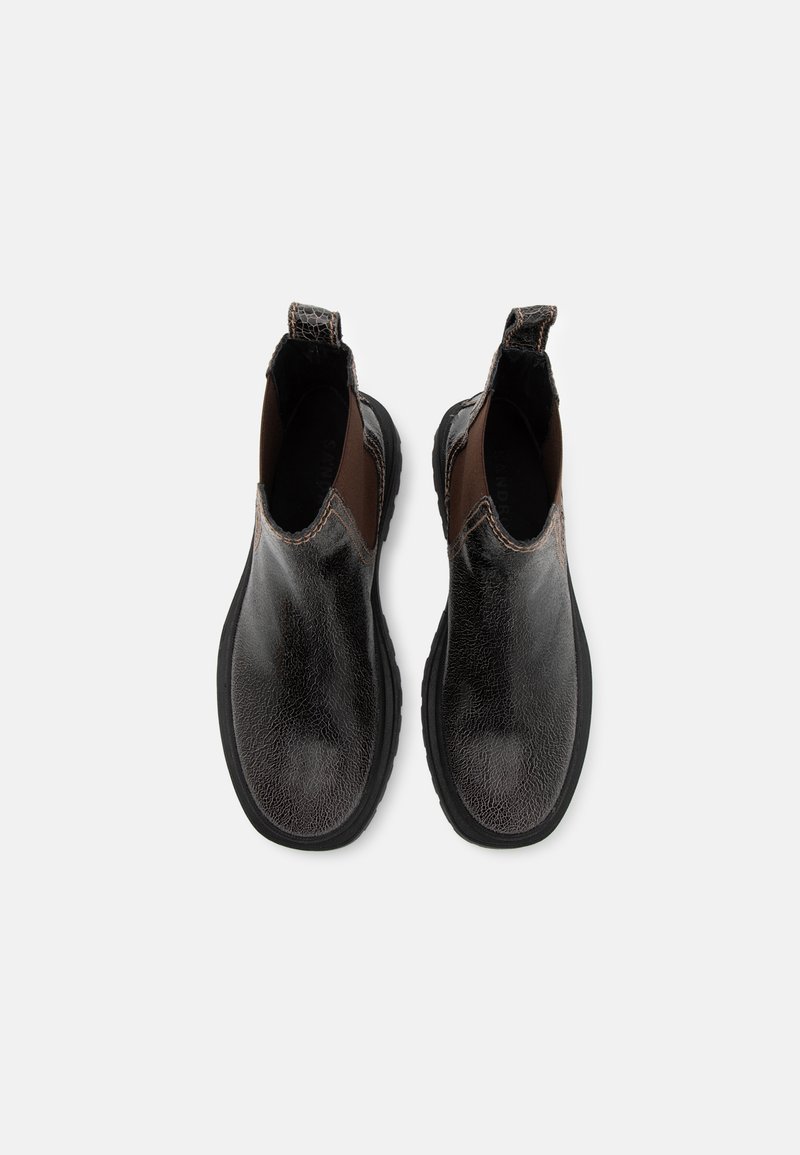 Schwarze Lederstiefeletten mit einer strukturierten Oberfläche, braunen elastischen Seiteneinsätzen und einer robusten schwarzen Gummisohle.