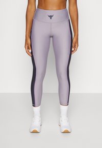 Höga leggings i ljus lila med mörka sidopaneler, med en texturerad yta och en liten tjurlogotyp vid midjan.