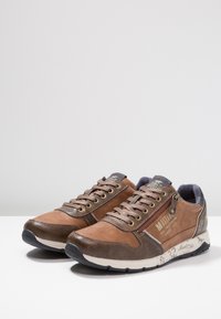 Baskets marron à lacets en suède et cuir, avec un design texturé, des accessoires en métal doré et une fermeture éclair sur le côté.