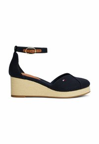 Marineblaue Segeltuch-Wedge-Sandalen mit geschlossenem Zehenbereich, verstellbarem Knöchelriemen und einer geflochtenen Jute-ähnlichen Plattform. Mit einem kleinen Logo-Detail.