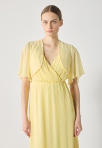 Yellow maxi dress with pleated texture, V-neckline, and flowy, layered short sleeves. Smooth, lightweight fabric.