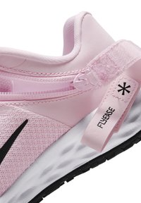 Różowy but sportowy z teksturowaną cholewką, czarnym znakiem Swoosh, wyraźnym językiem z oznaczeniem "FLYEASE" oraz białą, lekką podeszwą z czarną podeszwą zewnętrzną.