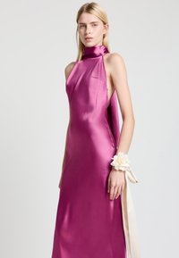 Satinkleid in lebhaftem Magenta mit hohem Kragen und offenen Seiten. Verfügt über ein florales Detail am Handgelenk und ein fließendes Design.