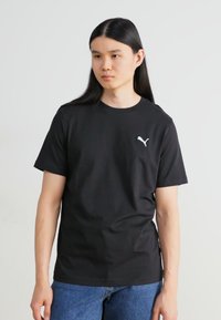 Černé bavlněné tričko s kulatým výstřihem a krátkými rukávy. Na levém prsu se nachází malé bílé logo Puma. Casual střih.