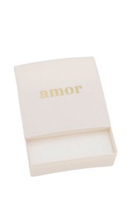Caja de joyería rectangular blanca con una tapa curvada, que presenta la palabra "amor" grabada en dorado. El interior está forrado con un tejido suave.