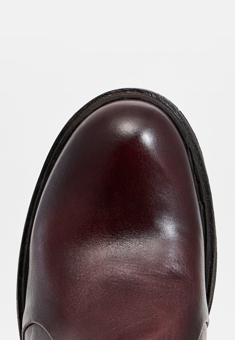 Scarpa in pelle bordeaux scuro con una finitura liscia e lucida. Design a punta tondeggiante e suola nera a contrasto con dettagli di cucitura sottili.