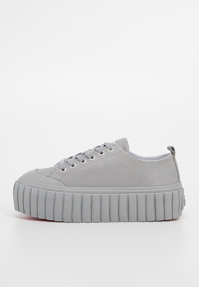 Szare sneakersy na platformie z gładką skórzaną cholewką, okrągłym noskiem oraz teksturowaną gumową podeszwą z wyraźnymi rowkami i zaokrąglonymi sznurówkami.