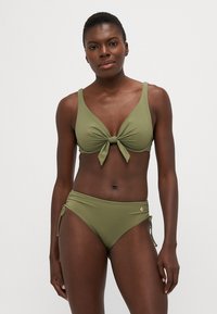Set bikinija u maslinastoj boji s topom s čvorom i odgovarajućim visokim dnom s bočnim vezicama i malim zlatnim detaljem.