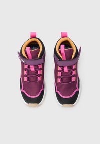 Een paar paarse en roze kindersneakers met klittenband en gele voering, tentoongesteld op een witte achtergrond.