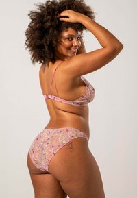 Roze doorschijnend lingeriesetje met delicate bloemenborduursels, dunne verstelbare bandjes en een zachte, rekbare stof voor comfort.