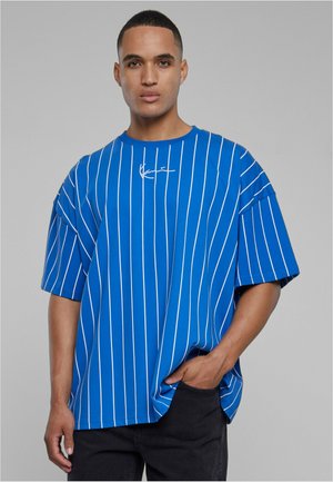 Mėlynas dryžuotas didelis T-shirt su baltais vertikaliais dryžiais ir apvaliu kaklu. Apatiniame kairiajame krūtinės kampe yra mažas siuvinėtas logotipas.