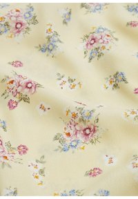 Tela de color amarillo claro con un patrón floral que presenta flores en tonos rosa y azul, textura suave y pequeñas hojas delicadas a lo largo.
