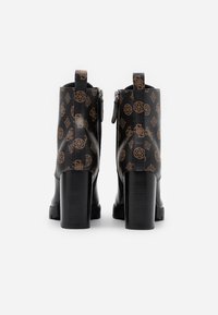 Černé kotníkové boty s hnědým dekorativním vzorem, masivní vysoké podpatky, zadní zip a poutka pro snadné obouvání. Hladký povrch, odolný materiál.