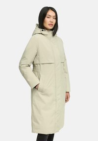 Lichtbeige waterdichte jas met een capuchon, voorzien van zijzakken, elastische accenten bij de taille en een recht gesneden ontwerp.