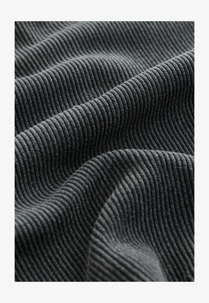 A textured szürke szövet függőleges ribbentéseket mutat, amelyek lágy, szőtt vonalakat idéznek. Az anyag puha megjelenésű, és egy kis fényes csillogással bír a redőkben.