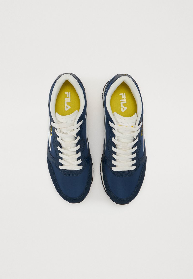 Scarpe sportive navy con lacci bianchi, suola strutturata e soletta gialla. Presentano il logo di lato e pannelli a contrasto.