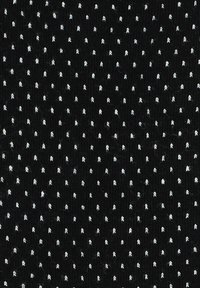 Czarna tkanina z małymi białymi kropkami, prezentująca teksturowaną powierzchnię. Wzór składa się z równomiernie rozmieszczonych kropek.