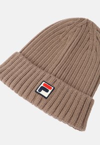 Berretto di maglia marrone con una trama a coste e risvolto. Presenta un'etichetta a colori con accenti rossi, bianchi e blu.