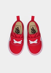 Baskets rouges pour tout-petits avec lacets blancs, semelles blanches et languettes de tirage, marque Vans, vues de dessus sur un fond blanc.